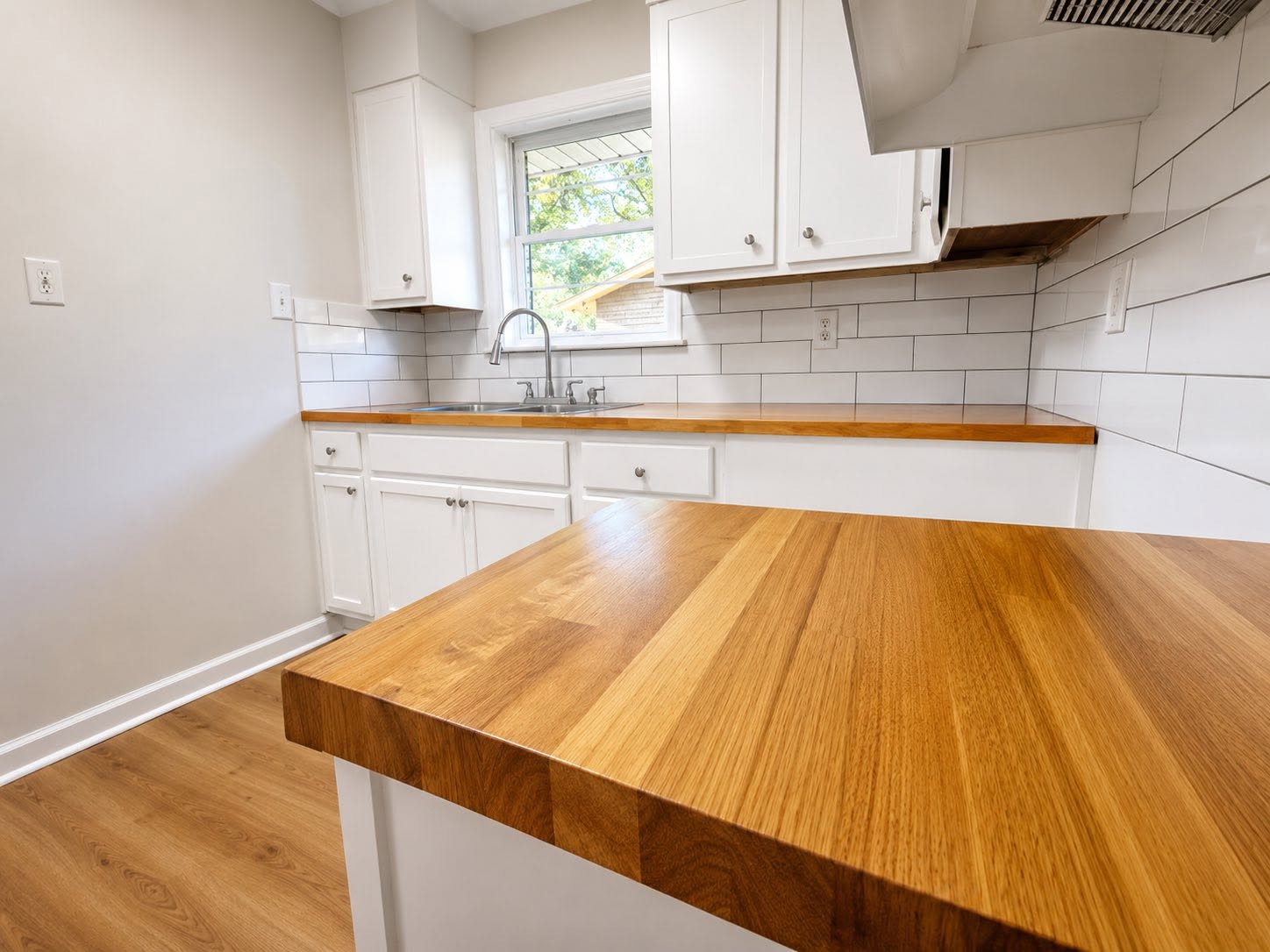 Remodeled Montgomery kitchen with white shaker cabinets, butcher-block island, and subway tile backsplash